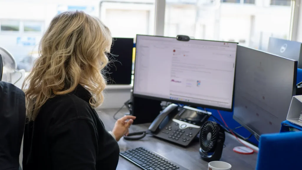 SciMed employee working at a multi-screen office workstation in Stockport